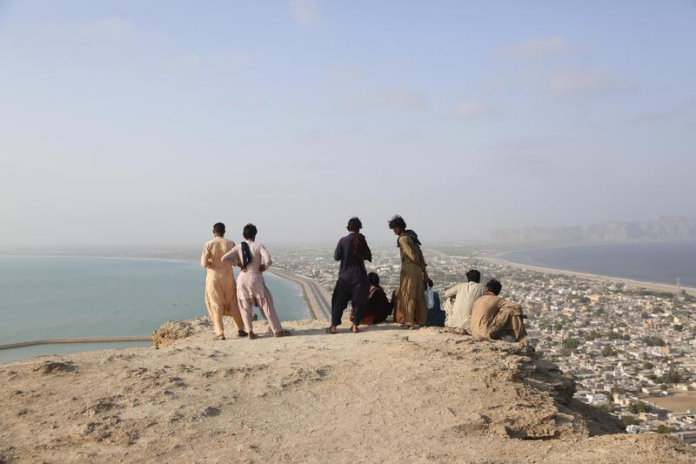 People admire the view from the top of a mountain in Gwadar, Pakistan